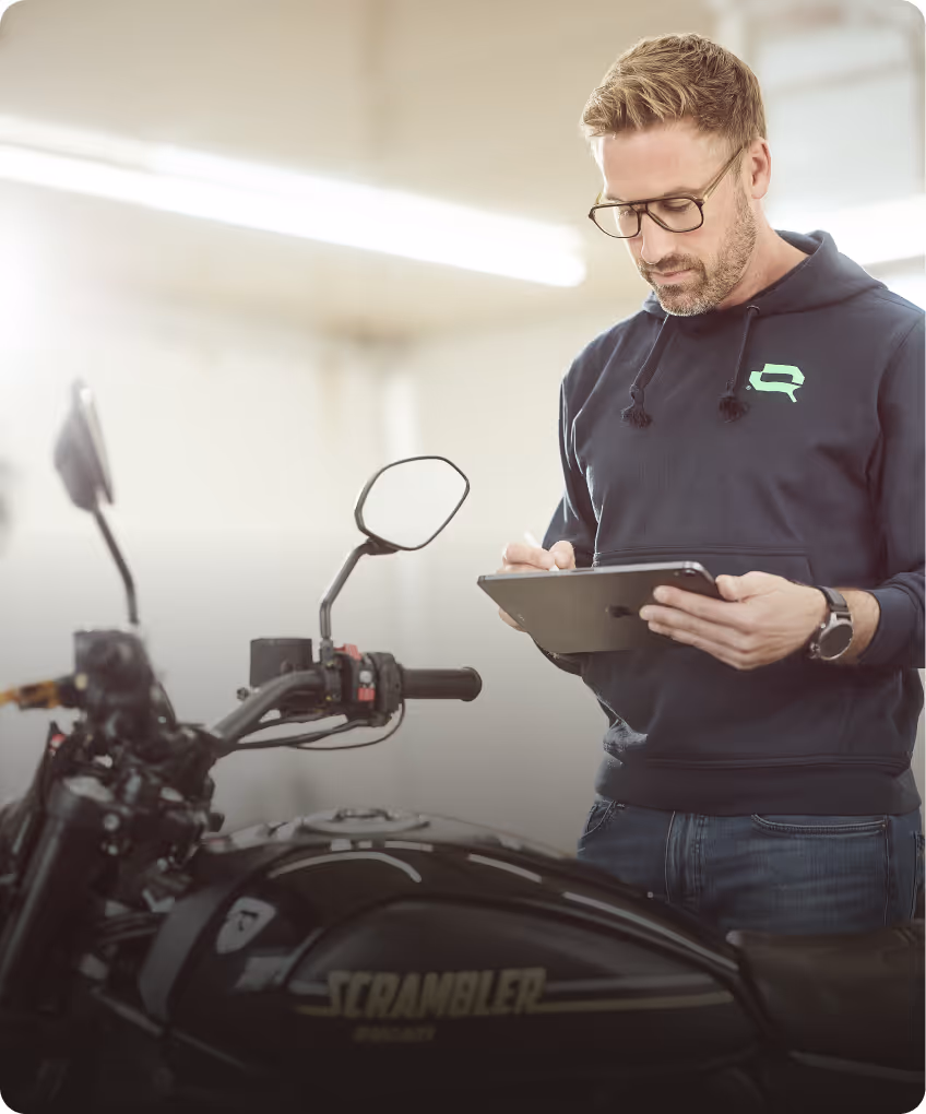 KFZ-Gutachter von Lotterschmid prüft ein Motorrad und dokumentiert die Fahrzeugbewertung sorgfältig.