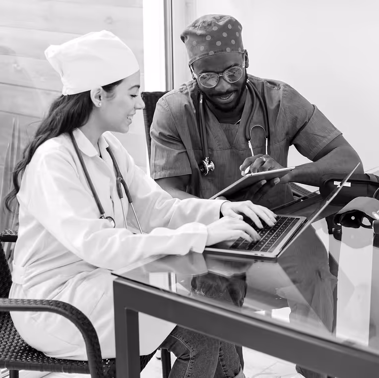 Healthcare workers at a glass table on a laptop