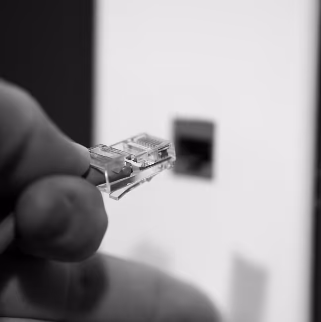 Closeup of hand plugging in ethernet cable