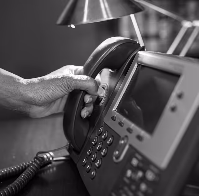Closeup of hand picking up a desk phone