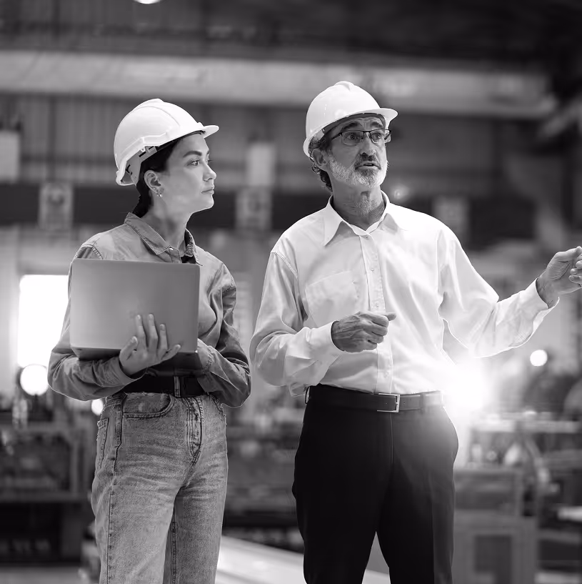 Two people with hardhats in a warehouse