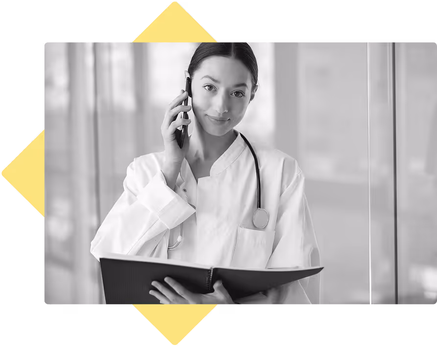 Doctor with a white coat and stethoscope on the phone, holding charts 