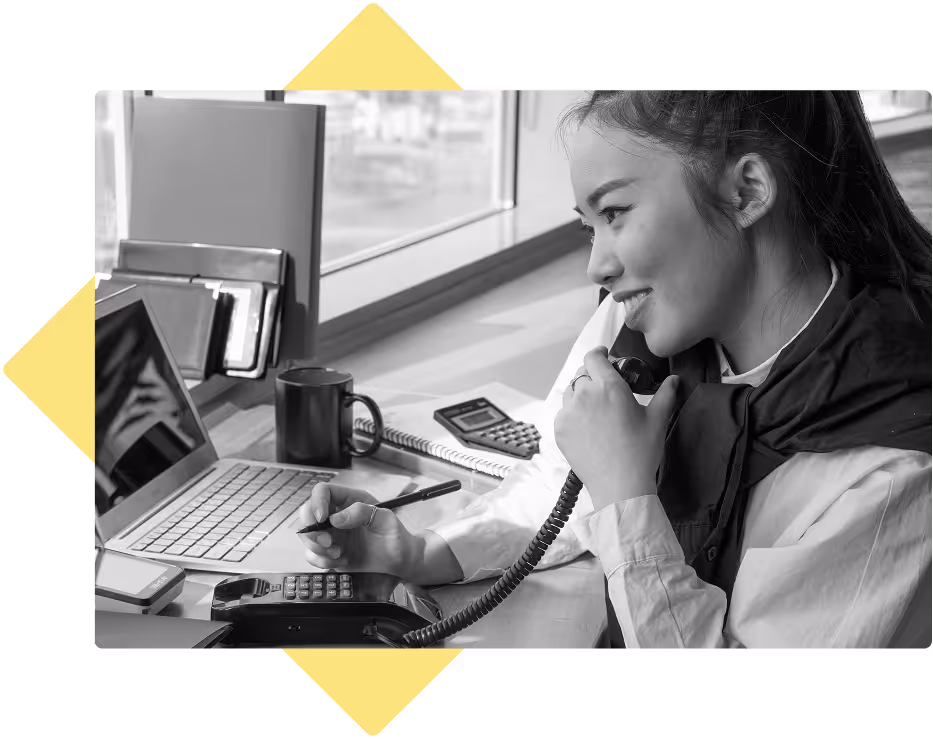 Education admin at her desk smiling while on the phone