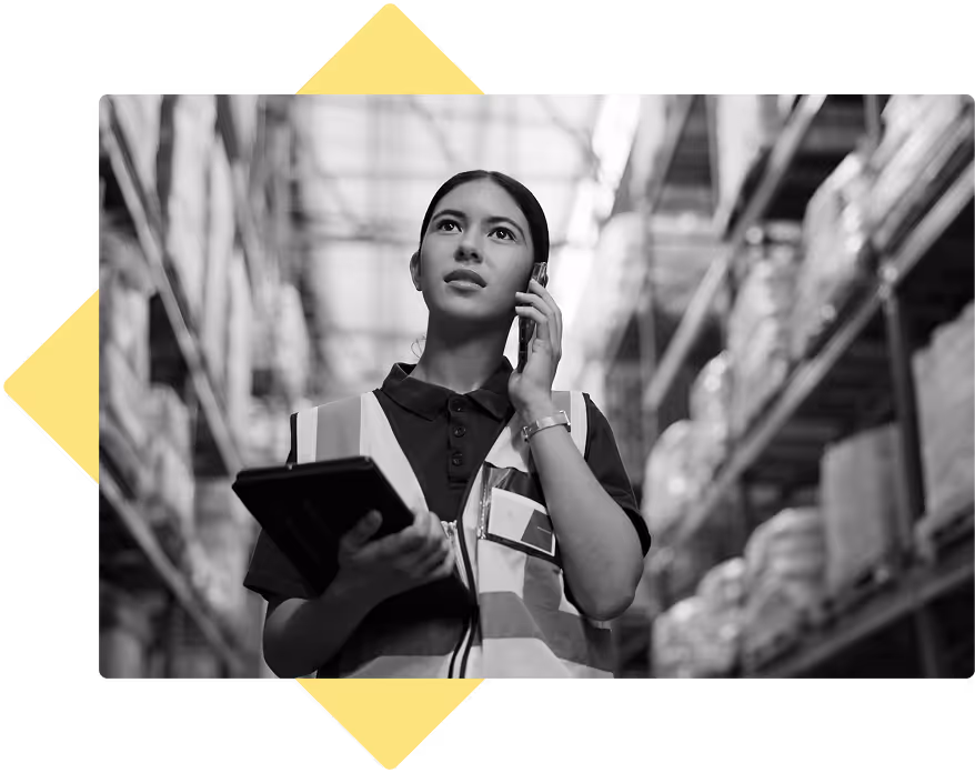Employee on the phone walking through a warehouse, holding a tablet