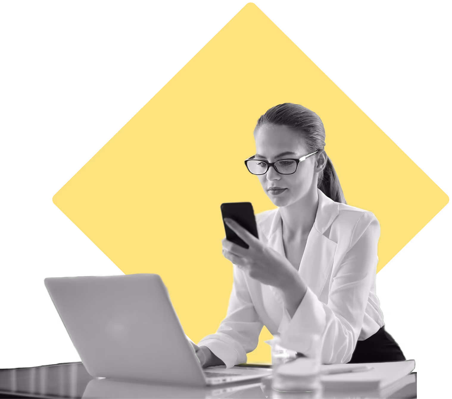 Business woman with glasses checking her phone while on her computer