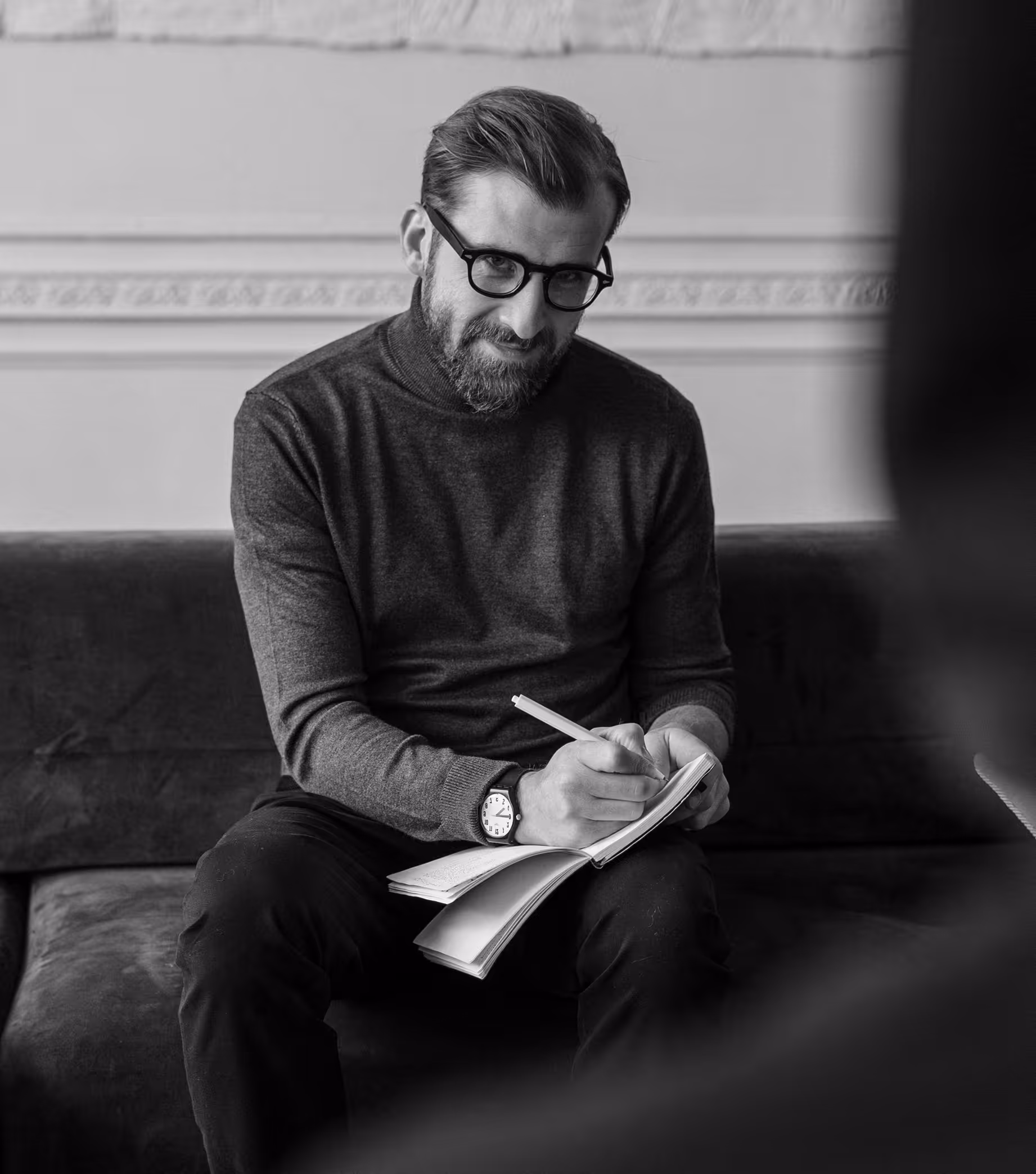 Solo therapy practitioner taking notes during a session smiling at client