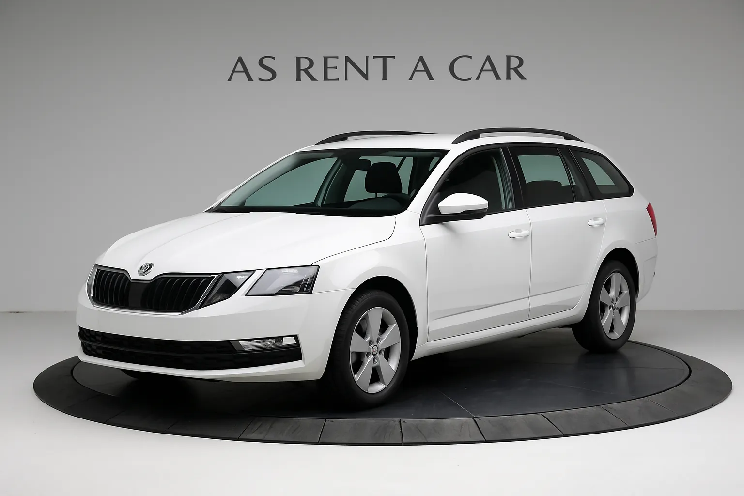 Weisser Kombiwagen auf einer Drehplattform vor grauem Hintergrund mit der Aufschrift AS RENT A CAR.