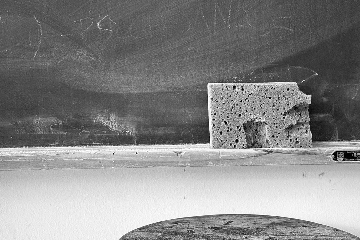 Tafel mit Schwamm, im Vordergrund Hocker