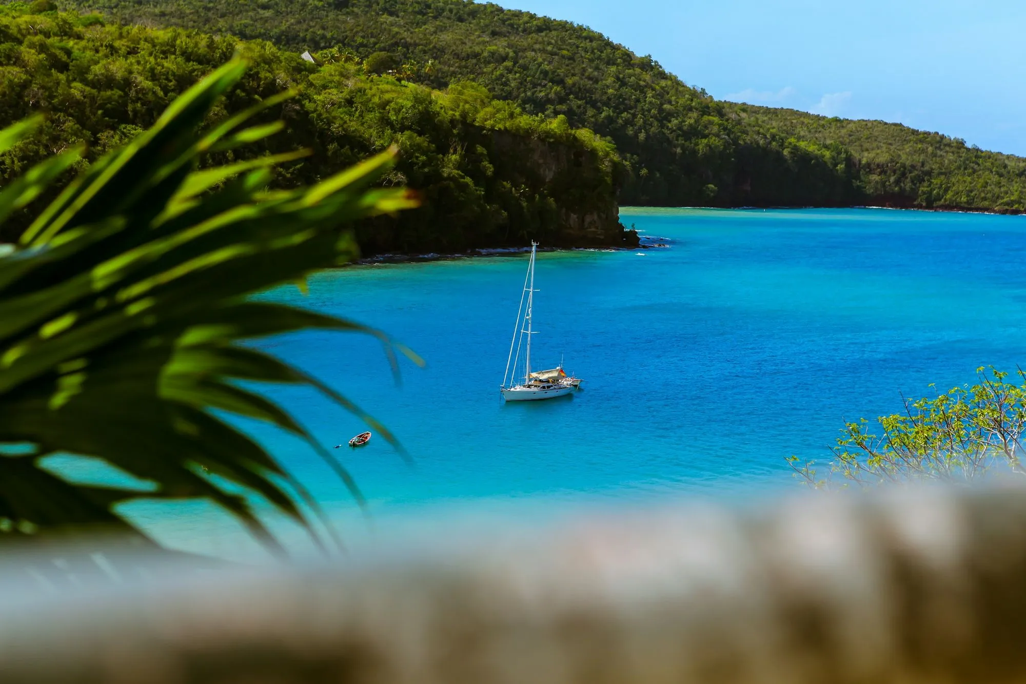 A sailboat floating on a blue body of water.