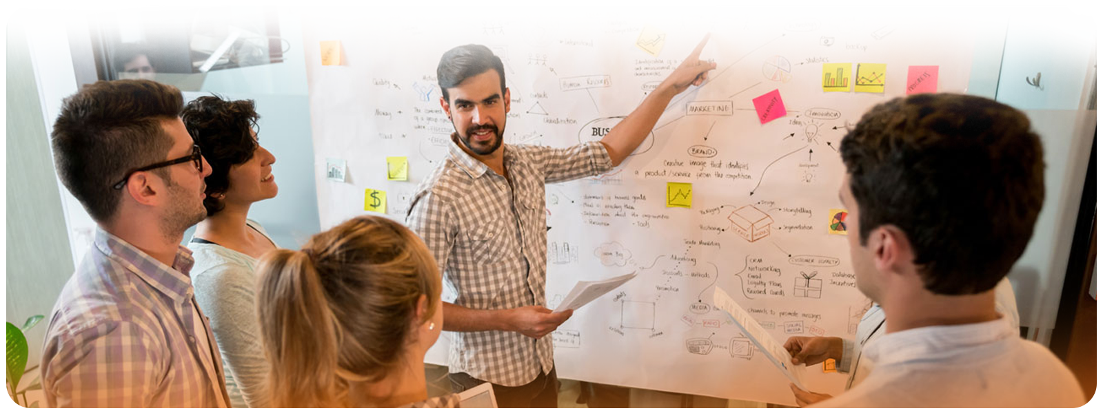 Team reviewing flowcharts and strategy on a whiteboard during a logistics planning session.