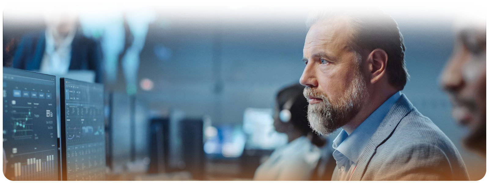 Professional team analyzing data dashboards in a modern control center with digital displays.