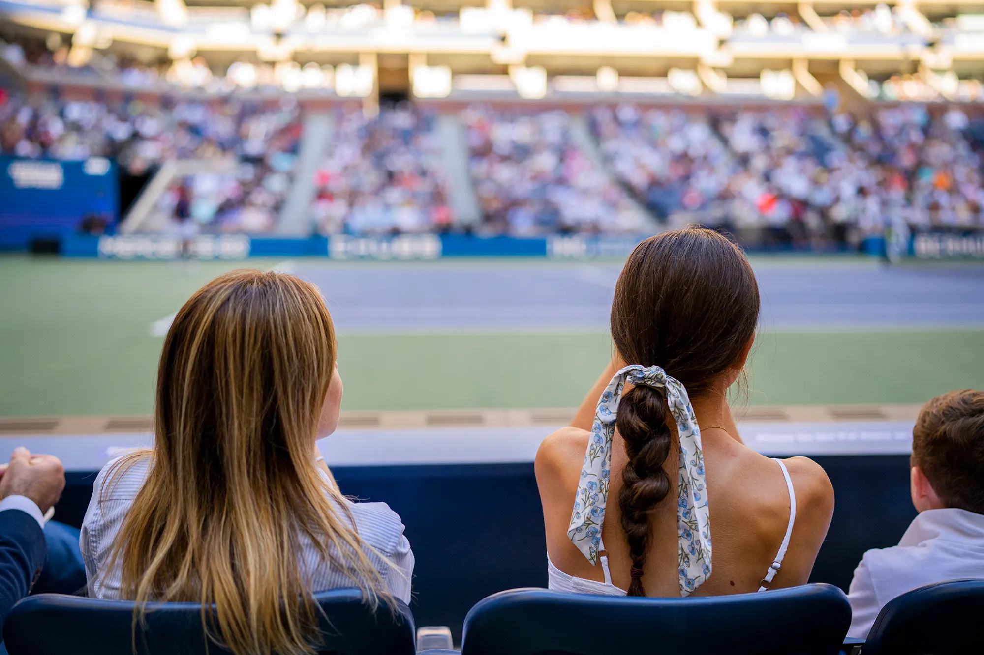 Tennis player hitting a backhand shot on a green court