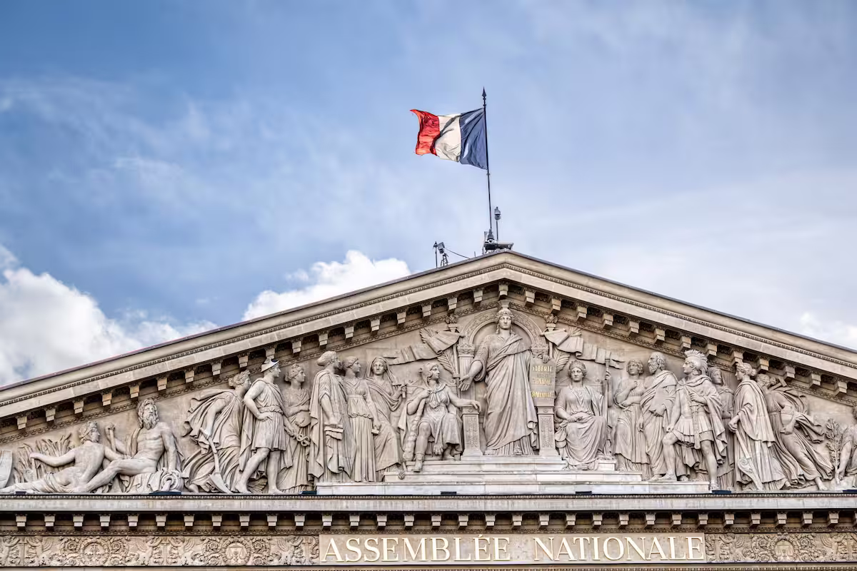 Façade de l’Assemblée Nationale française sous un ciel bleu, symbolisant la réforme fiscale et les évolutions législatives.