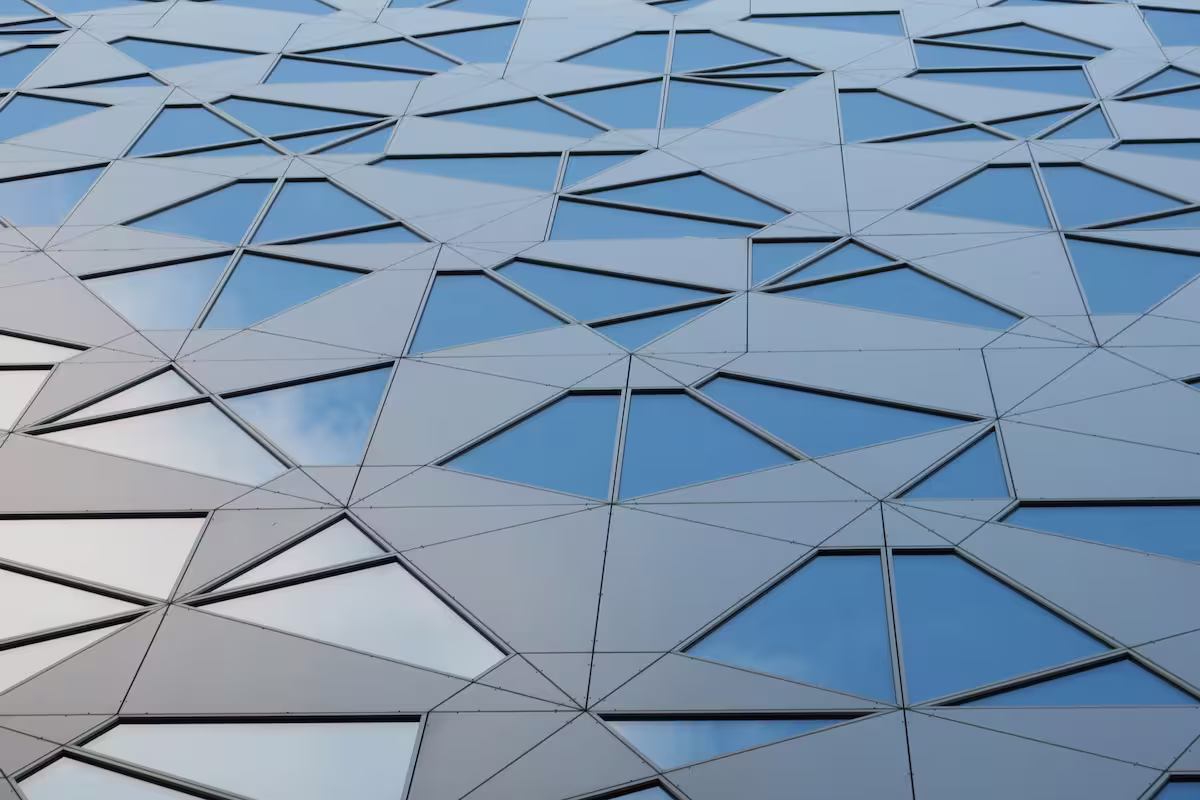 Un building vitré reflétant le bleu du ciel.