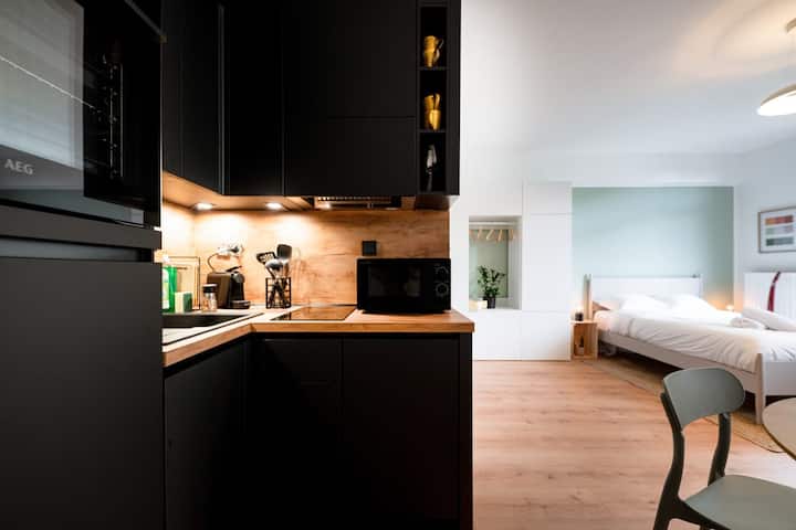 Kitchenette with modern cabinets and built-in appliances