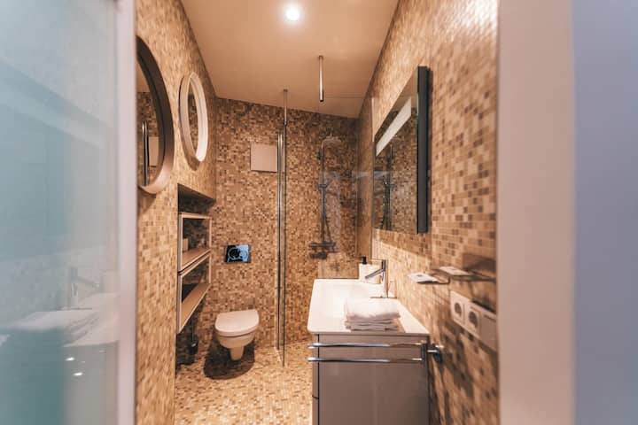 Modern bathroom with walk-in shower and stone tiles, 1BR Old Town Luxembourg