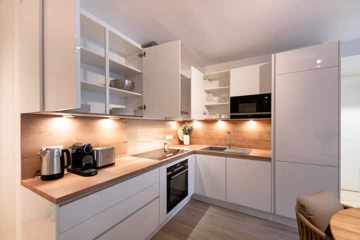 Modern kitchen with white cabinets, built-in oven and cooktop