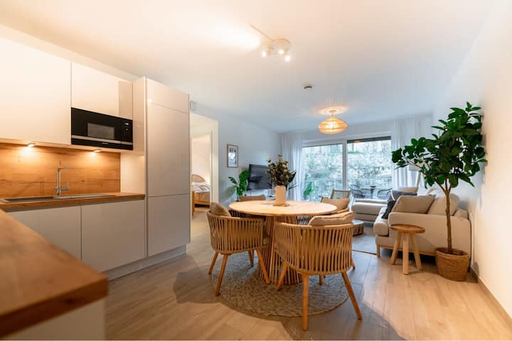 Open living and dining room with large windows and wood floors