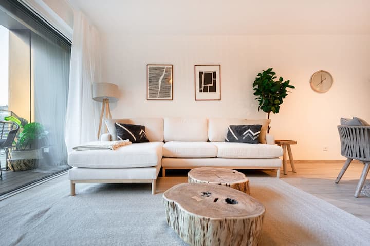 Bright living room with sofa, round table and houseplants, Hollerich 1BR