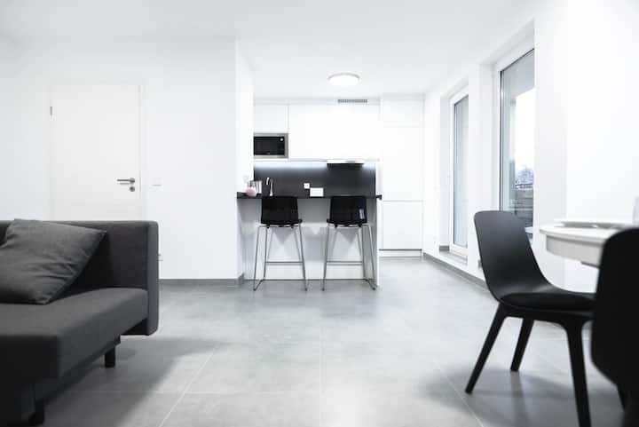 Sala de jantar com mesa redonda e duas cadeiras junto à janela