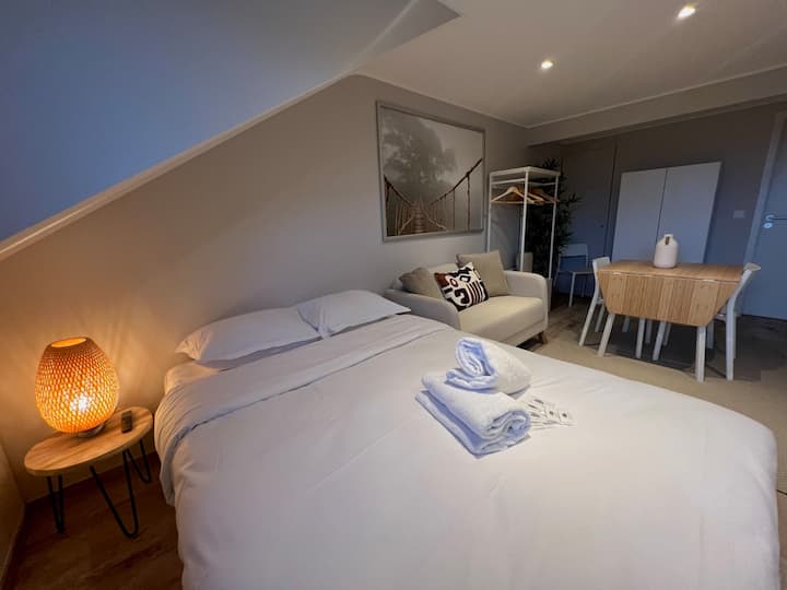 Cama de casal com almofadas e luz ambiente, estúdio loft