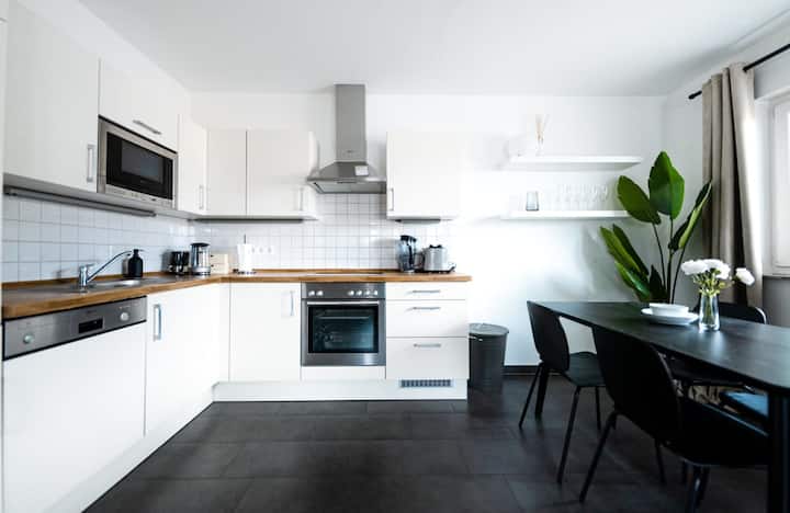 Cozinha branca com ilha e eletrodomésticos embutidos