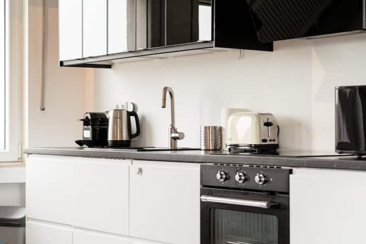 Modern kitchen with oven, cooktop and white cabinets, renovated 2BR