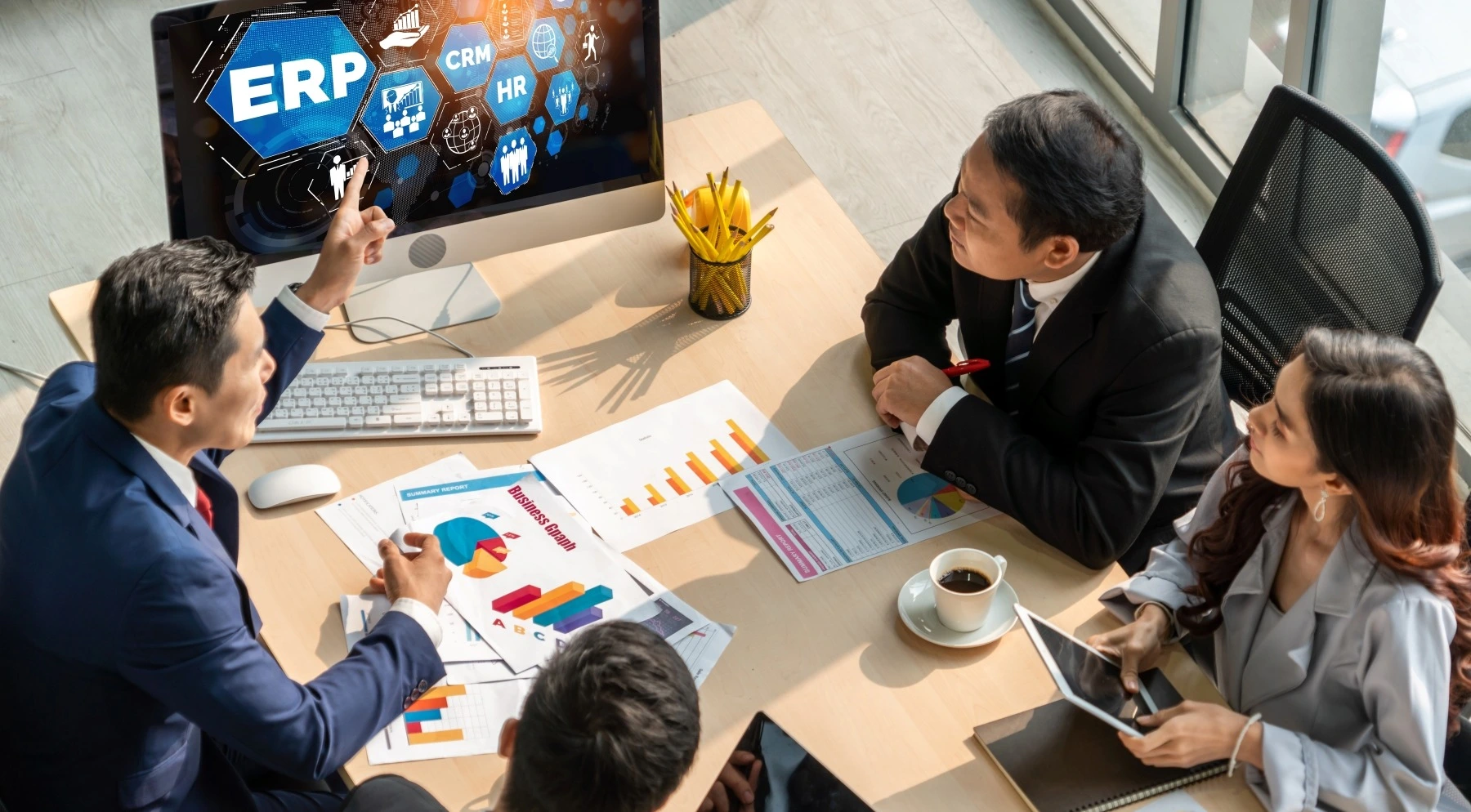 Business team analyzing ERP software and data charts in modern office