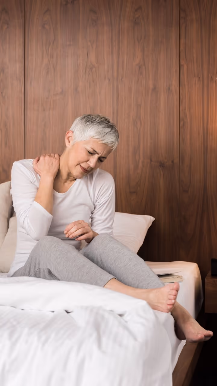 A woman experiencing neck and shoulder stiffness and pain.