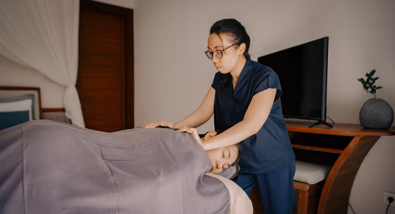 A therapist gives a client a relaxing  massage in a private room.