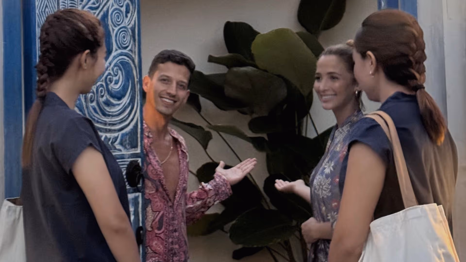 A friendly couple welcomes two therapists who have arrived at their villa to provide a home-service treatment.