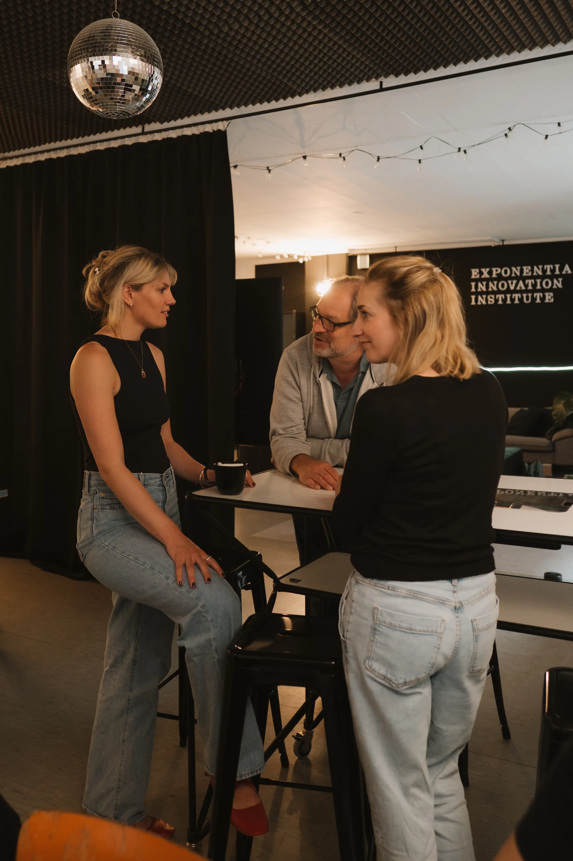 Drei Personen unterhalten sich an einem Tisch.