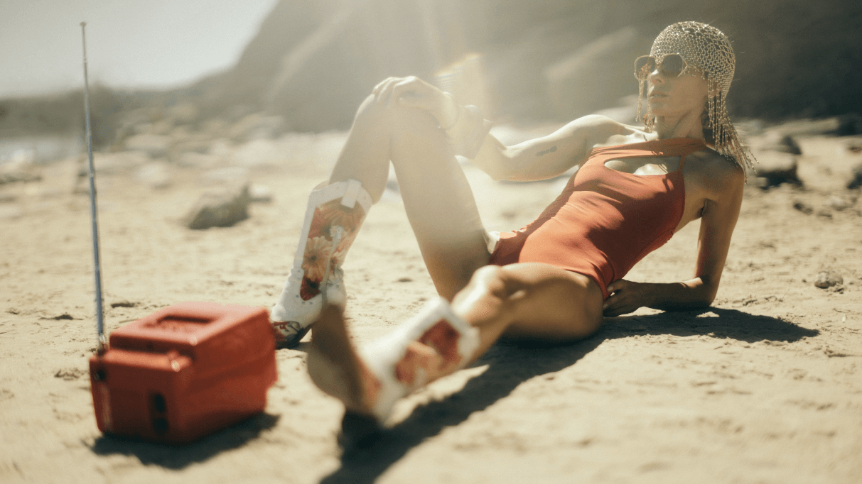 Woman on a beach with a red swimsuit and vintage radio