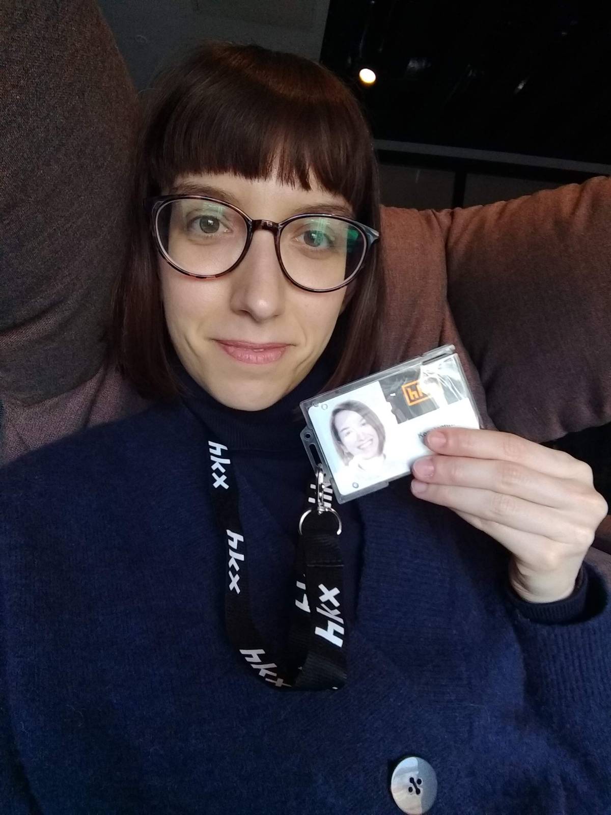 Selfie of Konnie showing her workpass on her first day as a UX designer