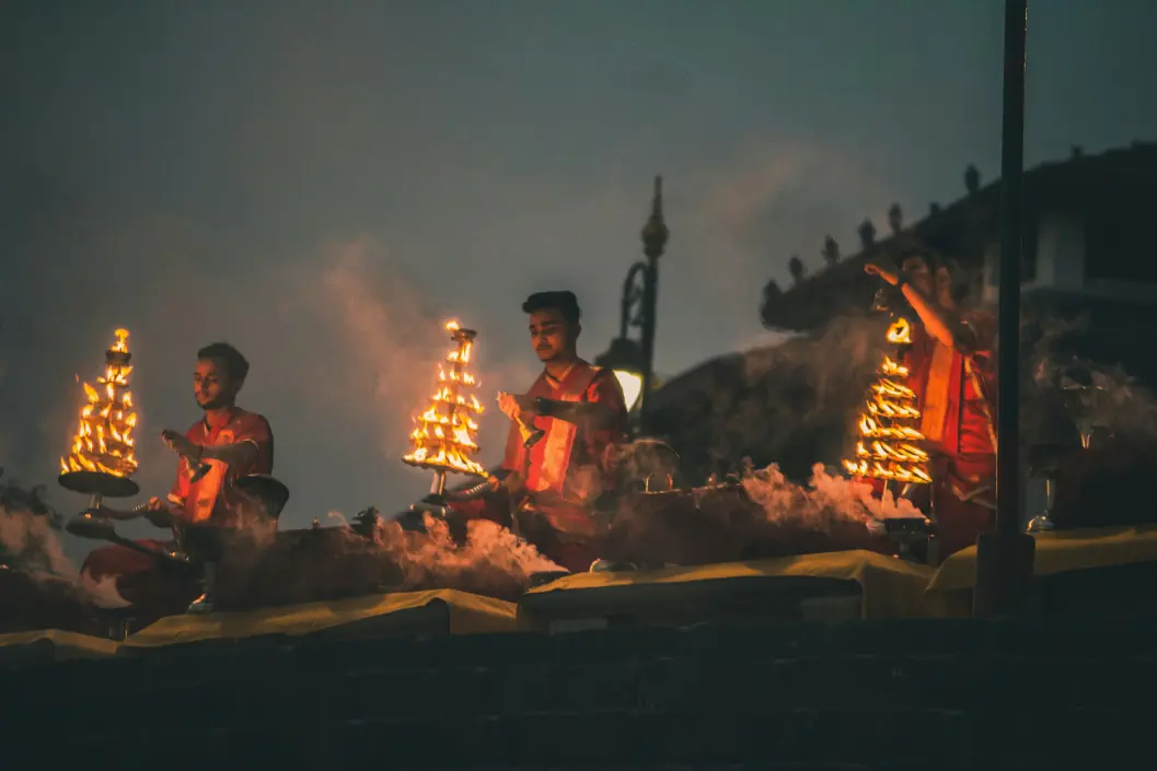 Evening Ganga aarti with rows of priests and glowing lamps along the riverfront