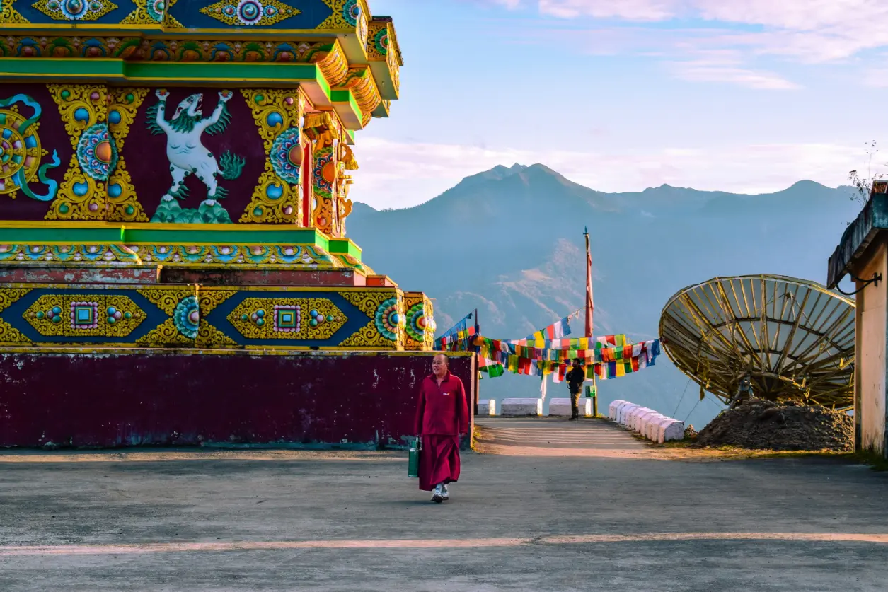 Colorful monastery structure with prayer flags and mountain views, capturing daily life in Tawang