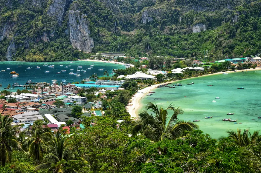 Scenic bay with turquoise water, boats, and limestone cliffs in Phi Phi Islands