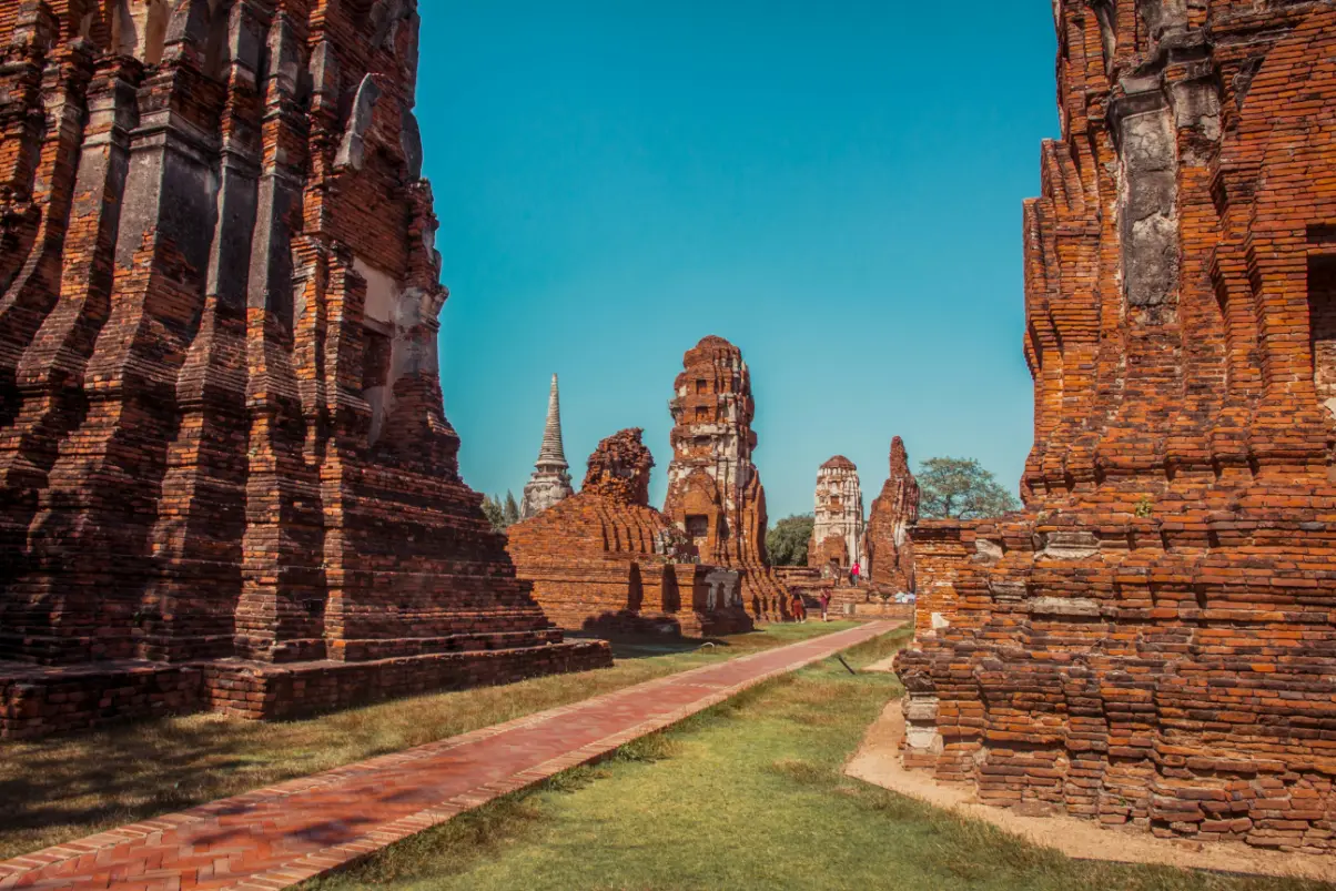 Ancient brick temple ruins lining a pathway in Ayutthaya historical park