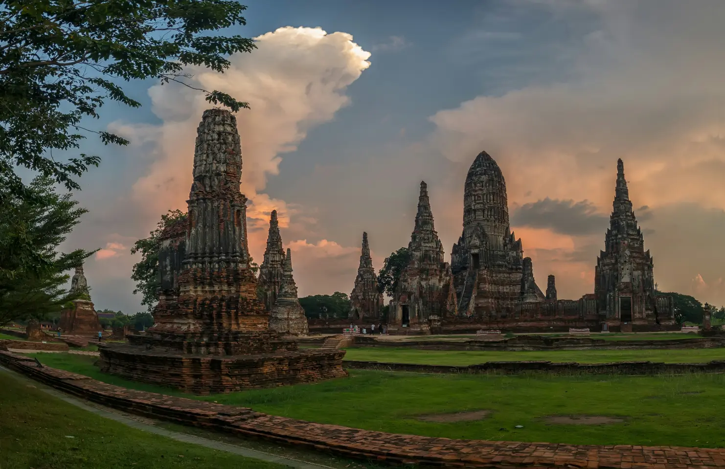 Wide view of Ayutthaya temple complex with towering prangs at sunset