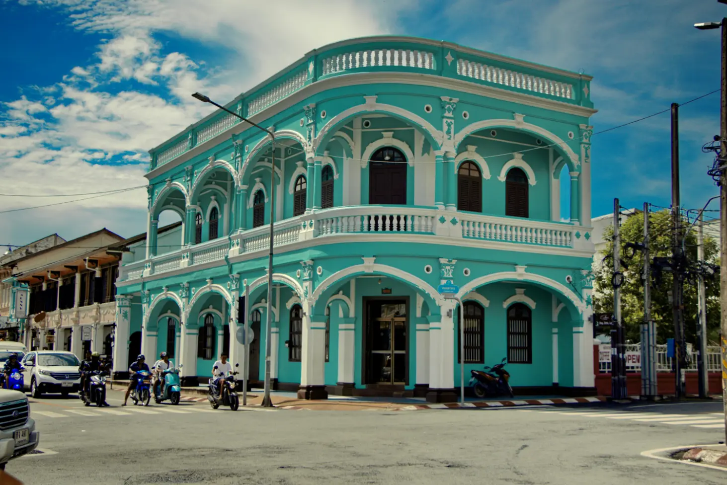 Pastel turquoise heritage building with arched balconies at a street corner in Phuket Old Town