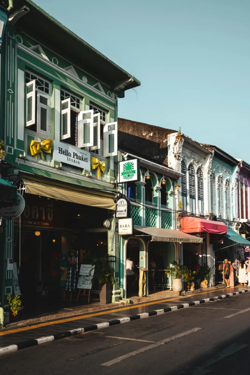 Colorful heritage shophouses lining a street in Phuket Old Town during golden hour