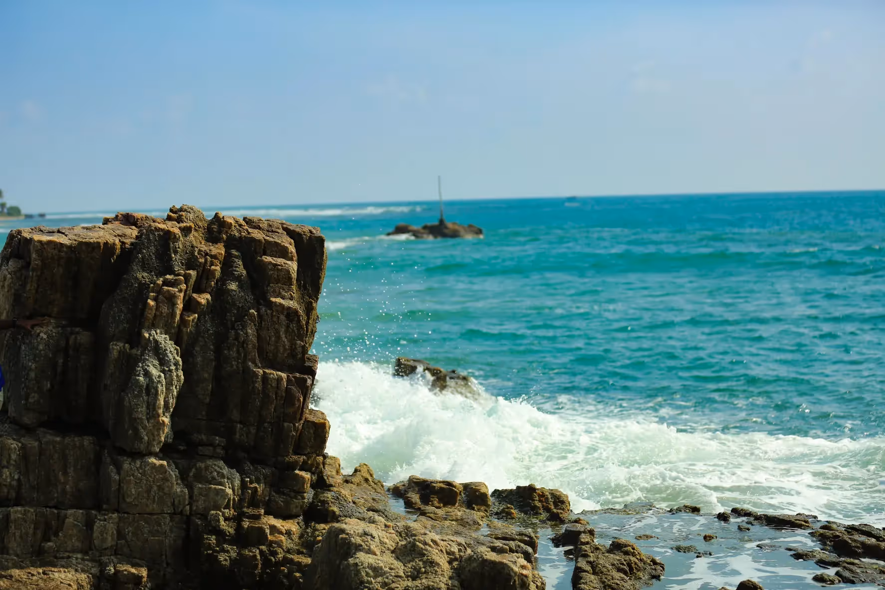 Crystal-clear turquoise ocean at Trincomalee, Sri Lanka with coral reef visible beneath calm shallow waters