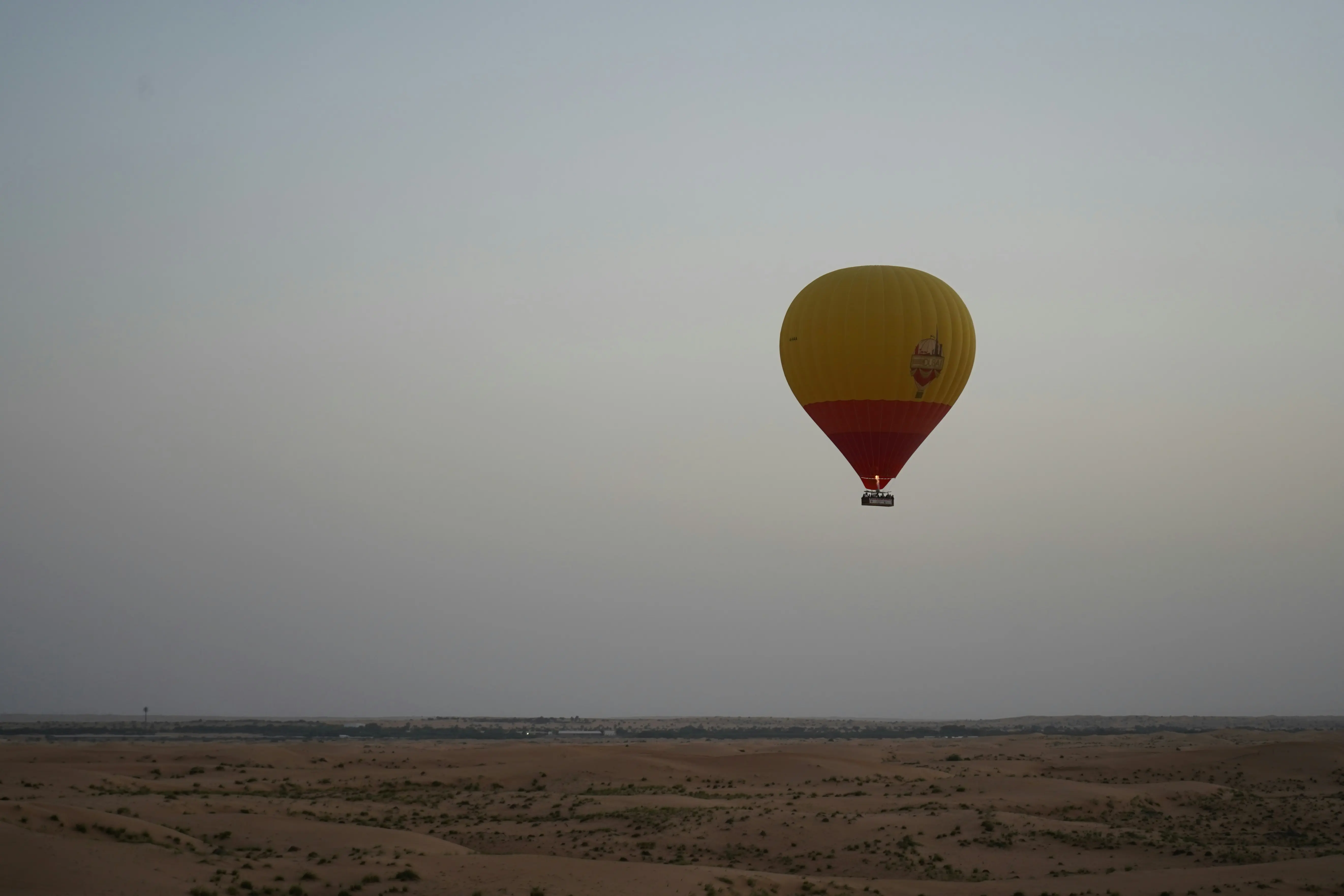Aerial view of golden sand dunes from hot air balloon Dubai morning flight
