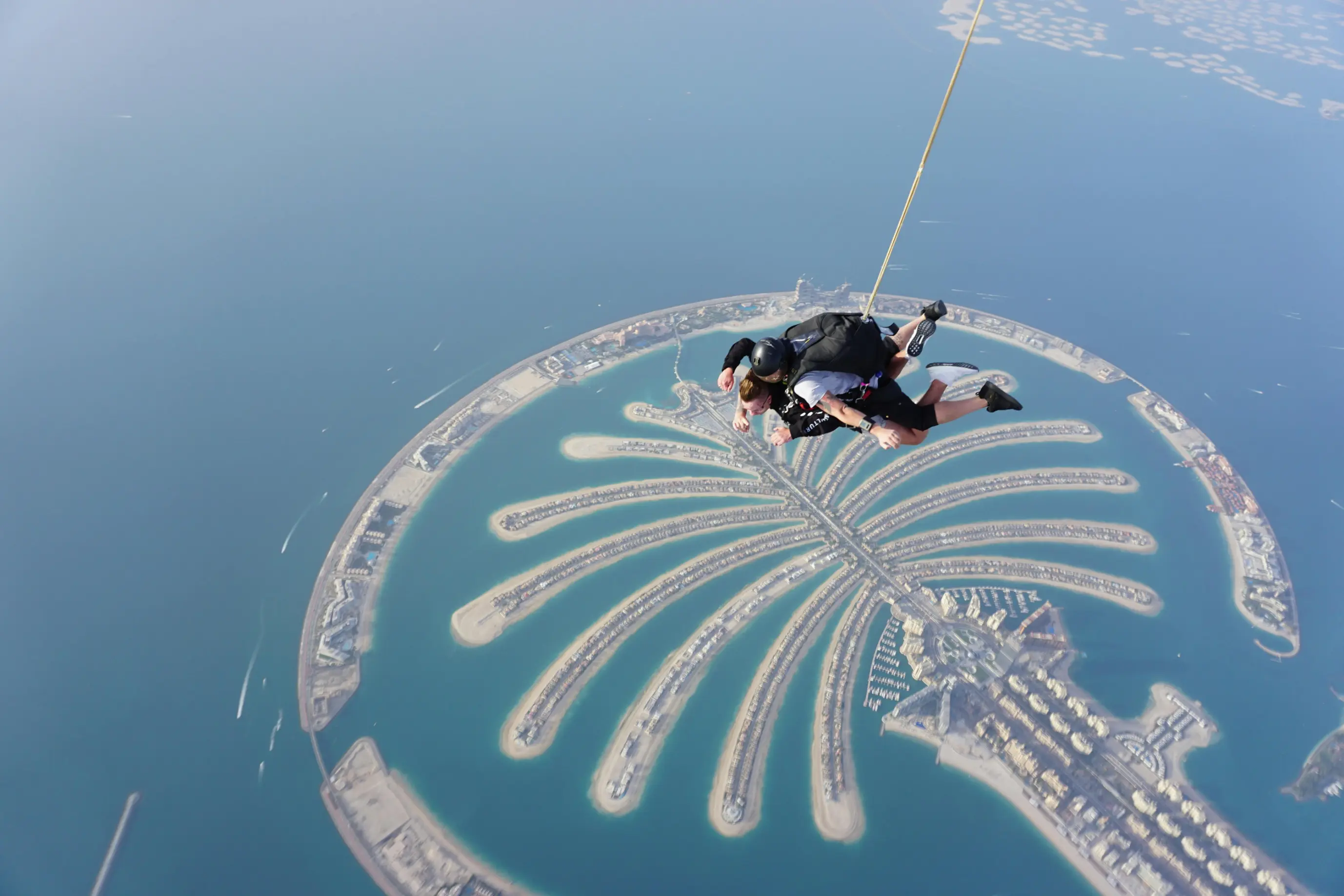 Tandem skydiver freefall above Palm Jumeirah coastline Dubai