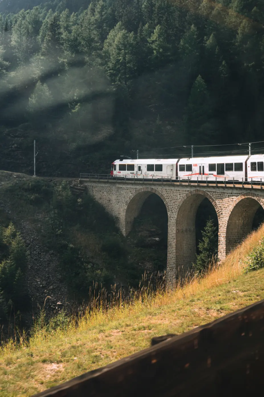 Glacier Express train crossing bridge Switzerland Alps