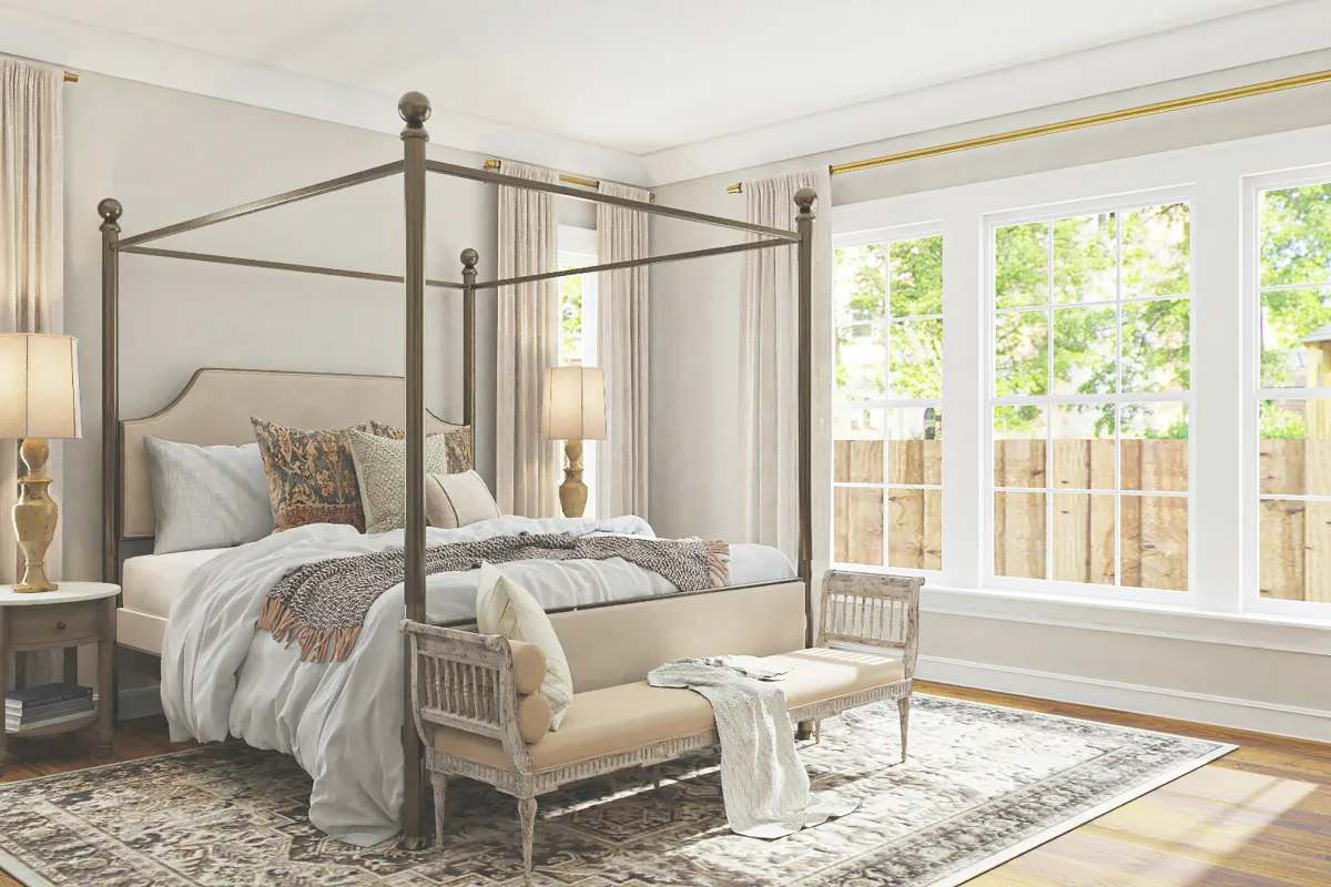Four post bed in room with large windows