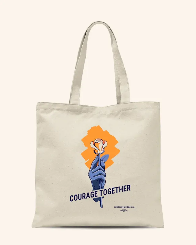 A canvas tote-bag with a logo of a hand holding an orange rose and the words "Courage Together"