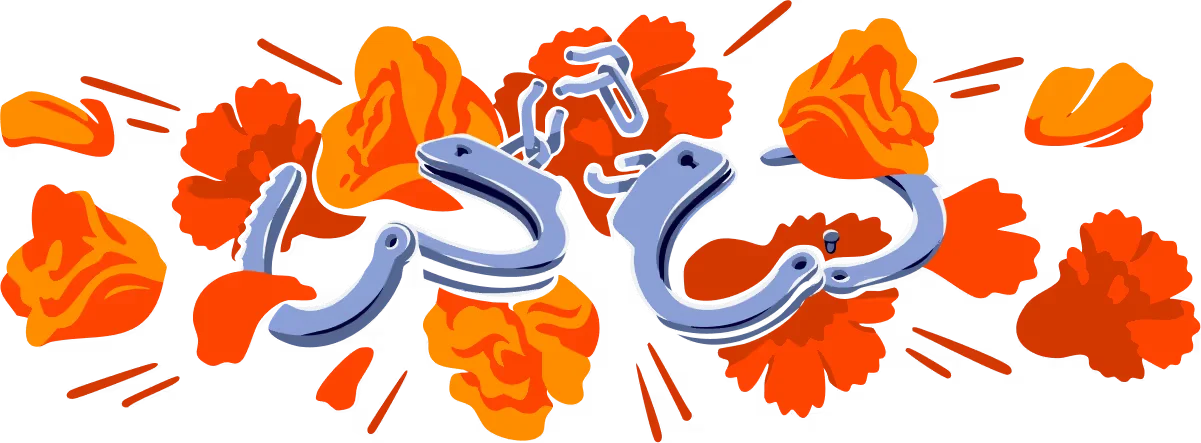 A pair of broken, open handcuffs in front of red and orange flowers