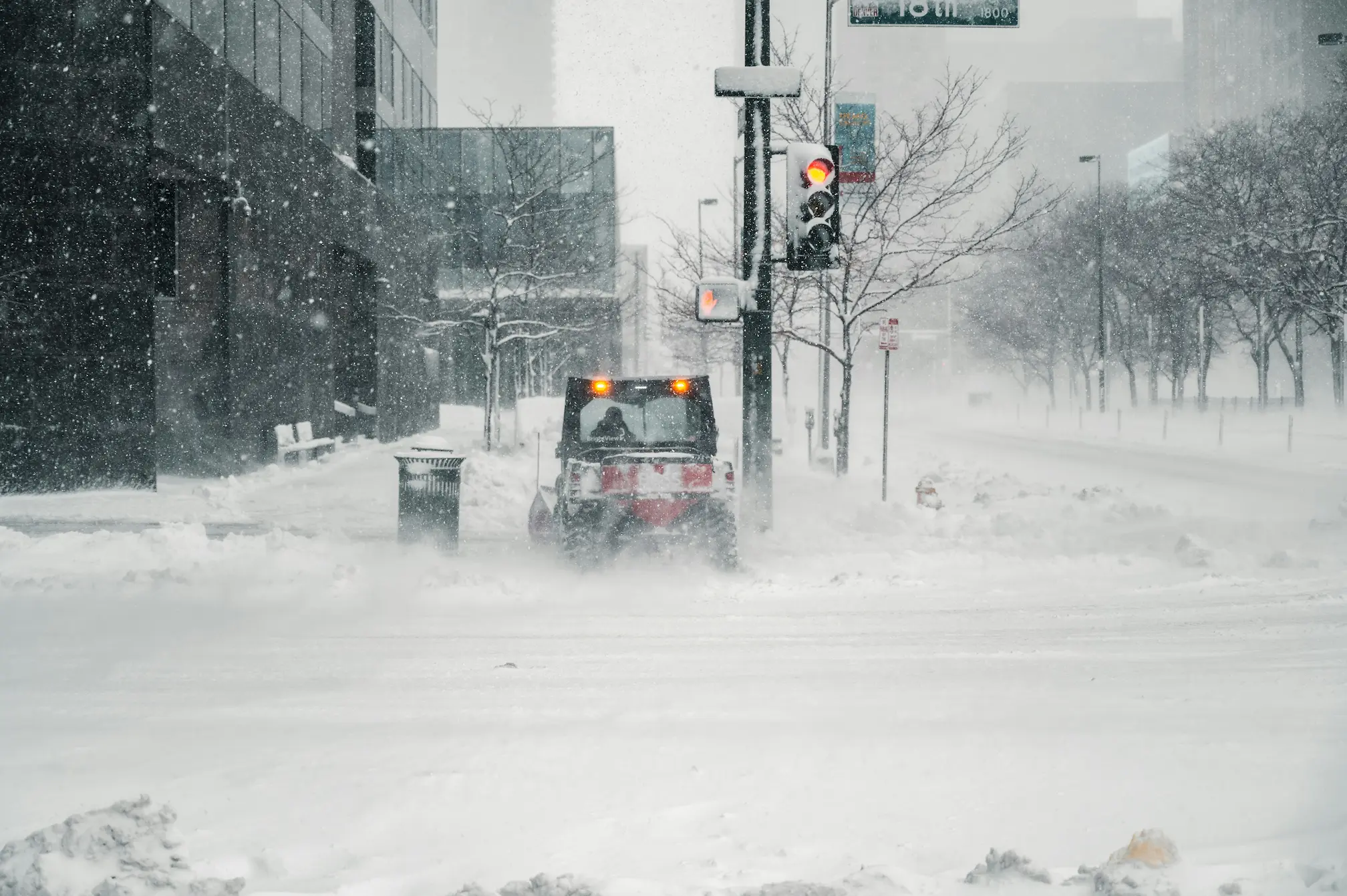 Snow plough clearing a city street during a winter storm