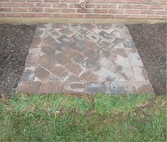 Organized brick pad on side of house
